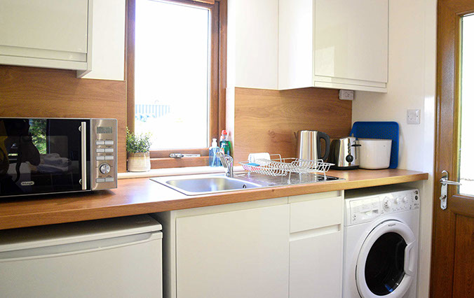 Kitchen with microwave washing machine fridge toaster at Chracaig Bheag in Portree