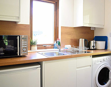 Kitchen with microwave washing machine fridge toaster at Chracaig Bheag in Portree