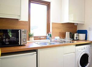 Kitchen with microwave washing machine fridge toaster at Chracaig Bheag in Portree