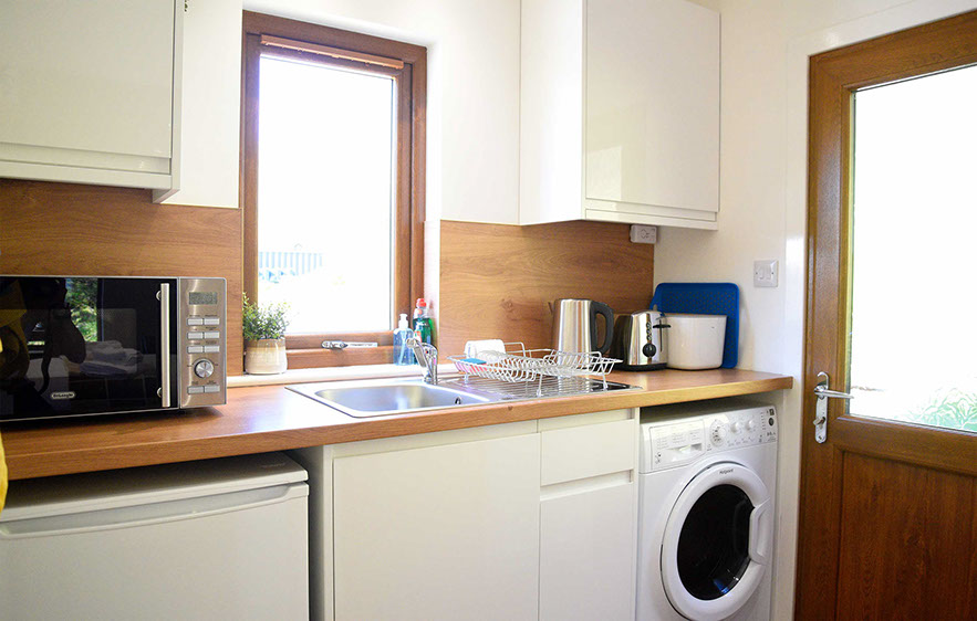Kitchen with microwave washing machine fridge toaster at Chracaig Bheag in Portree